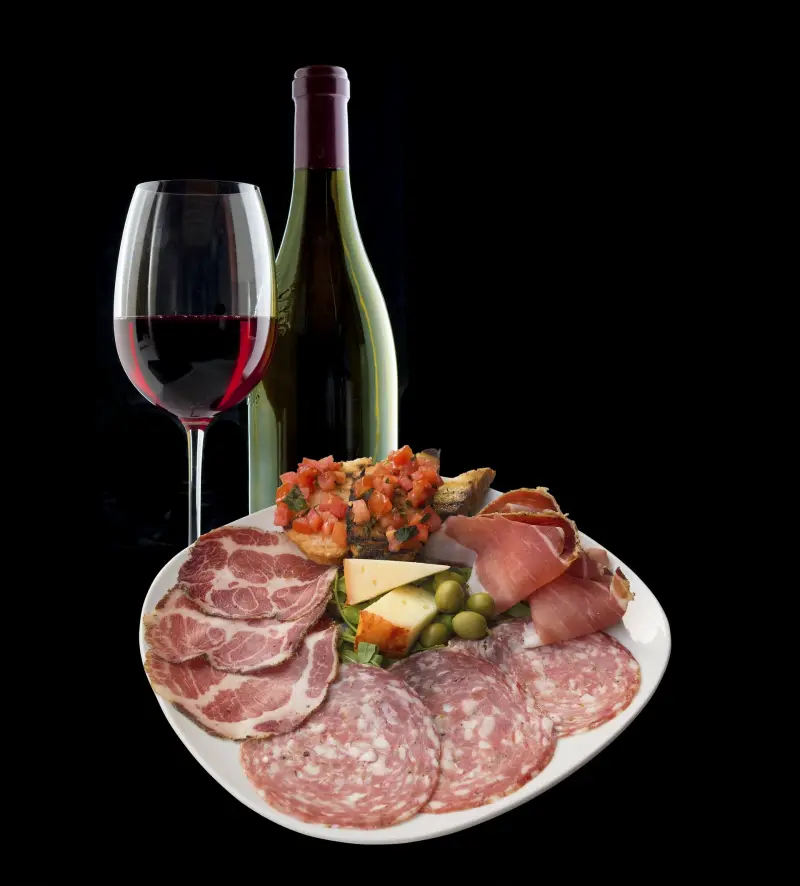Bord met vleeswaren en een glas rode wijn